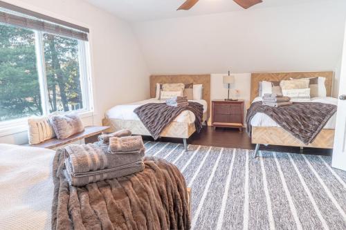 a bedroom with three beds and a window at Lakefront Lookout- 14 S in Fort Ann