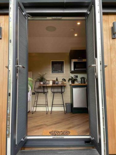 an open door to a kitchen with a table at Newydd Lodge with private hot tub in Llangollen