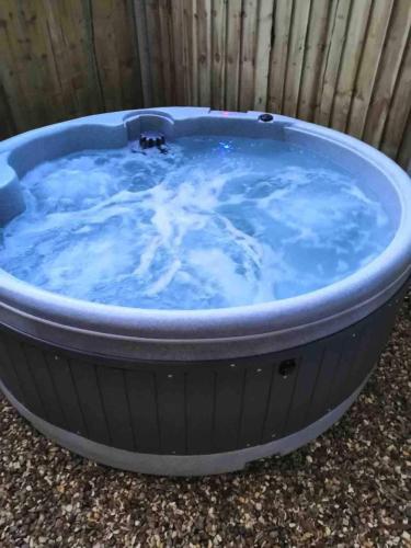 a large hot tub filled with blue water at Newydd Lodge with private hot tub in Llangollen