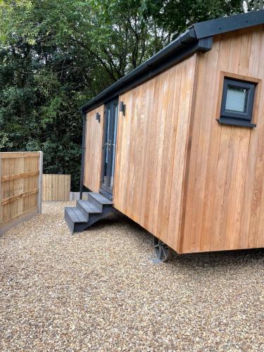 a wooden shed with a door and a staircase at Newydd Lodge with private hot tub in Llangollen
