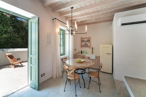 a kitchen and dining room with a table and chairs at Nisomar Suites in Symi