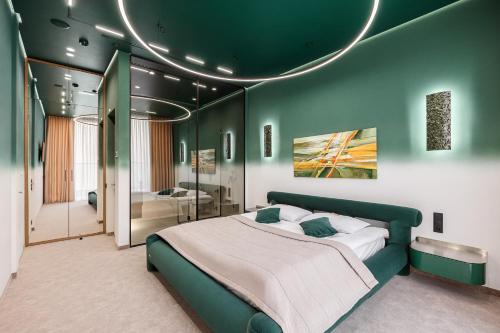 a bedroom with a large bed with a green wall at Tavel Hotel & SPA in Bukovel