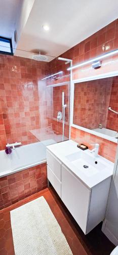 une salle de bain avec un lavabo blanc et une baignoire dans l'établissement L'Odyssée Vercors - Ski - Randonnée, à Villard-de-Lans