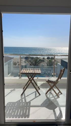 a table and chairs on a balcony overlooking the ocean at شالية ماربيا الاشخرة Marbella Ashkhara Chalet in Al Ashkharah