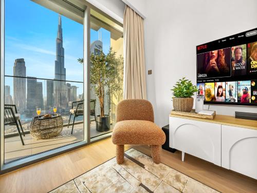 a living room with a chair and a large window at The Burj Khalifa Suite Luxury 2-bed in Burj Royale in Dubai