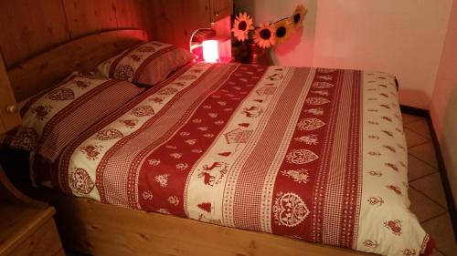 Una cama con manta y almohadas. en Casa Vacanze Corteno Golgi Aprica, en Alpe Strencia