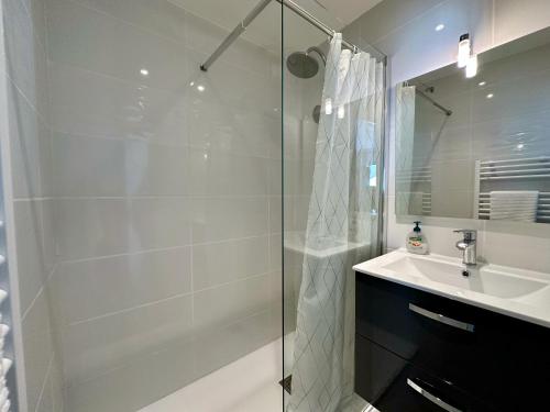 une salle de bain blanche avec une douche et un lavabo dans l'établissement Side Ocean View Studio, 24H Check-In and Out, Air Conditioner, Close to Airport, à Cagnes-sur-Mer