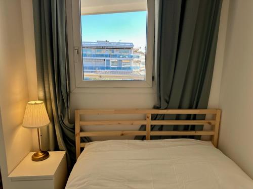 une petite chambre avec un lit et une fenêtre dans l'établissement Side Ocean View Studio, 24H Check-In and Out, Air Conditioner, Close to Airport, à Cagnes-sur-Mer