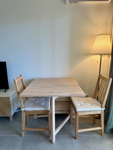 une table en bois avec deux chaises et une lampe dans l'établissement Side Ocean View Studio, 24H Check-In and Out, Air Conditioner, Close to Airport, à Cagnes-sur-Mer
