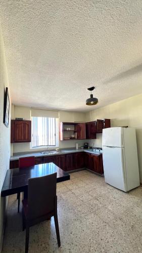 a kitchen with a refrigerator and a table in a room at Departamento sencillo LM in Los Mochis