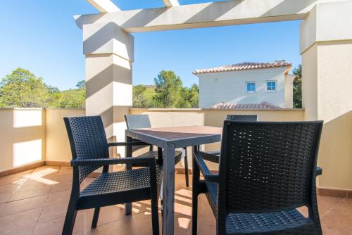 a patio with a table and chairs on a balcony at Castro Marim Golfe and Country Club in Castro Marim