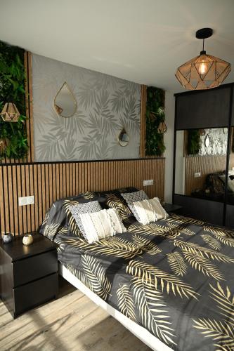 une chambre avec un grand lit et un mur avec des plantes dans l'établissement Love Room Luxe Près de la Mer, à Fréjus