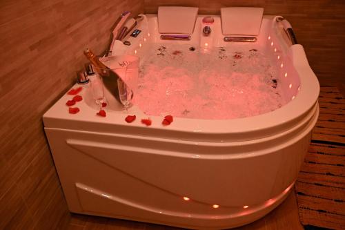 une baignoire jacuzzi remplie de liquide rose dans l'établissement Love Room Luxe Près de la Mer, à Fréjus