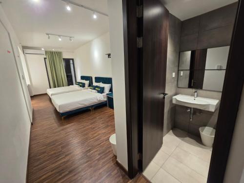 a bathroom with a bed and a sink in a room at K Avenue Kota Kinabalu by Merveille - Sabah in Donggongon