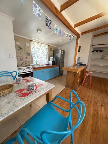 a kitchen with a blue chair in a room at Cabaña Delfin in Maitencillo