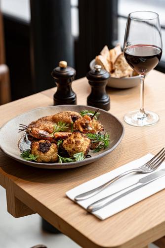 a plate of food on a table with a glass of wine at Grand Pigalle Experimental in Paris