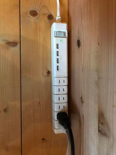 a remote control hanging on a wooden wall at 南箱根ツリーハウス in Kannami