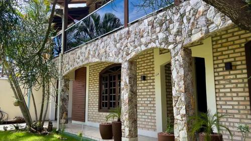 a house with a brick facade with plants on it at Casa espaçosa com sala de jogos interna e externa in Florianópolis