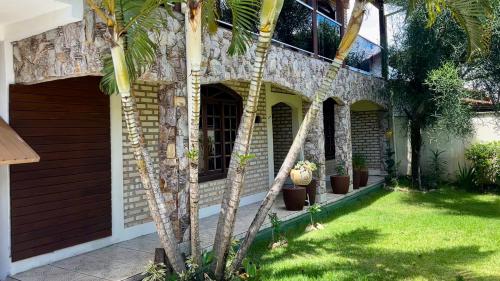 a house with a palm tree in the yard at Casa espaçosa com sala de jogos interna e externa in Florianópolis