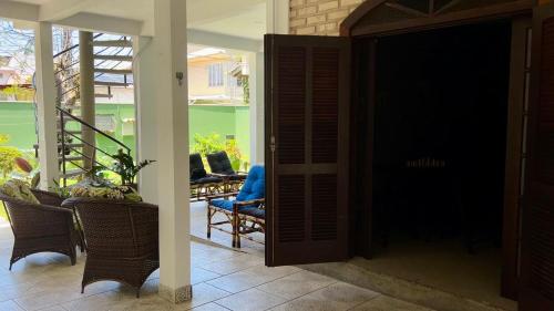an open door to a porch with chairs and tables at Casa espaçosa com sala de jogos interna e externa in Florianópolis