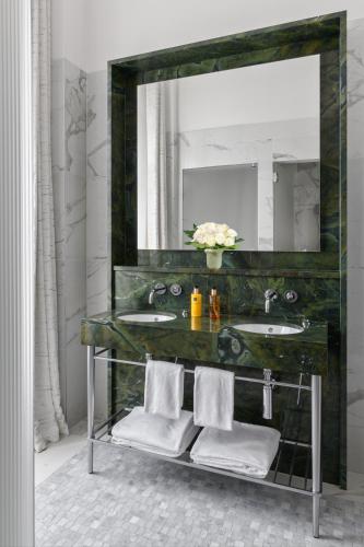a bathroom with two sinks and a large mirror at Hôtel Métropole Genève in Geneva