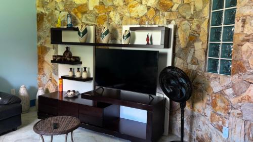 a living room with a flat screen tv on a wall at Casa espaçosa com sala de jogos interna e externa in Florianópolis