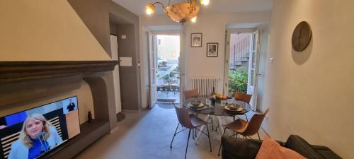 a living room with a dining room table and a fireplace at THERESA DELUXE Italia in Cannobio