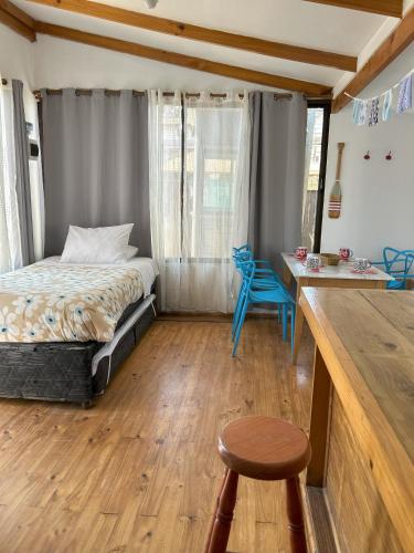 a bedroom with a bed and a table and a stool at Cabaña Delfin in Maitencillo