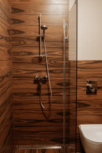 a shower in a bathroom with wooden walls at Villa Paula in Polanica-Zdrój