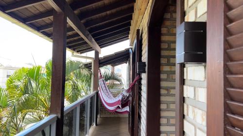 a hammock hangs on the porch of a house at Casa espaçosa com sala de jogos interna e externa in Florianópolis
