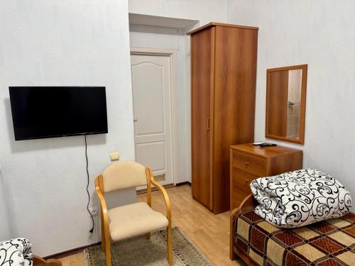 a living room with a chair and a tv on a wall at Hotel Anastasia in Rezina