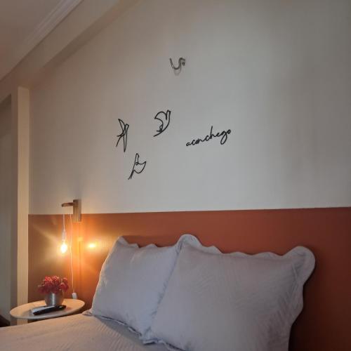 a bedroom with a bed with writing on the wall at Casa Rosa Suítes 5 min de caminhada da PRAIA DA PONTA NGRA in Manaus