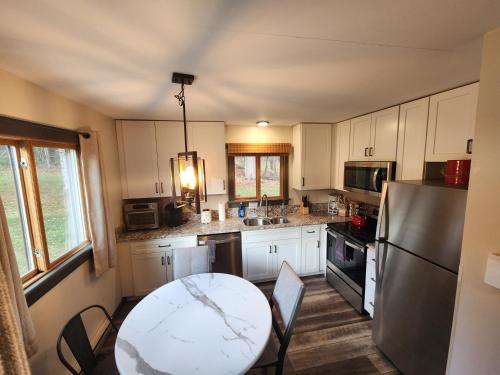 a kitchen with a table and a refrigerator at Ski in/out Spruce Glen Townhomes on Great Eastern Trail in Killington