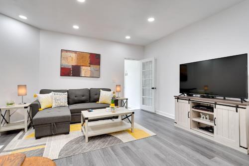 a living room with a couch and a flat screen tv at Philly Hub Near World Cup and Downtown Attractions! in Philadelphia