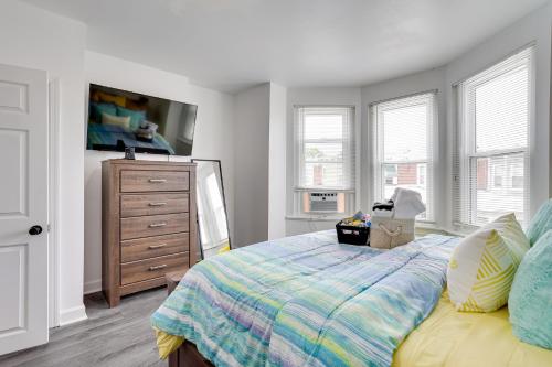 a bedroom with a bed and a dresser and windows at Philly Hub Near World Cup and Downtown Attractions! in Philadelphia