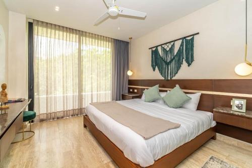 a bedroom with a bed and a large window at 3BR Penthouse with Private Plunge Pool in Tulum
