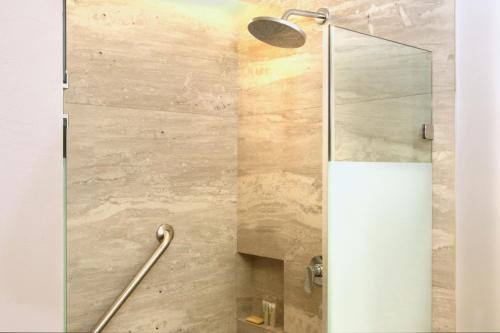 a shower with a glass door in a bathroom at City Express Plus by Marriott Monterrey Centro in Monterrey