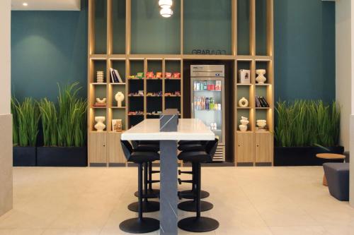a table and two stools in a room with a refrigerator at City Express Plus by Marriott Monterrey Centro in Monterrey