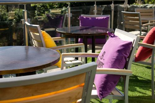 a group of tables and chairs with purple cushions at The Birchtree Hotel in Dalbeattie