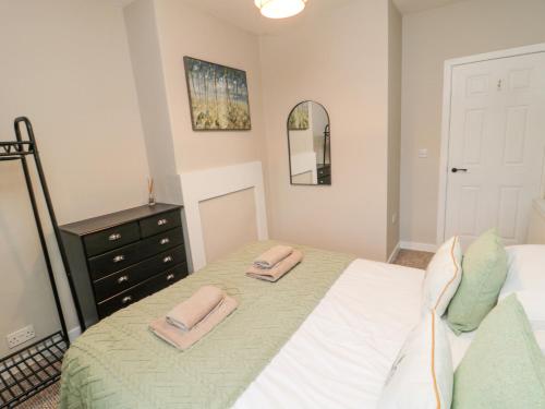 a bedroom with a bed and a dresser and a mirror at Castle Keep in Berwick-Upon-Tweed