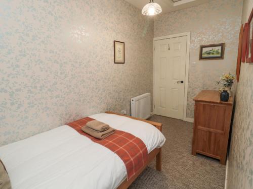 a bedroom with a bed and a dresser and a door at Castle Keep in Berwick-Upon-Tweed