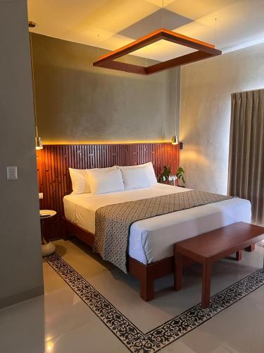 a bedroom with a large bed with a wooden headboard at Hotel Poquito a Poquito in Valladolid