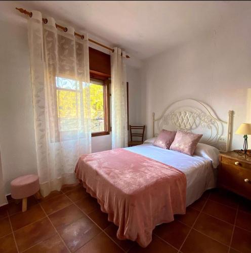 a bedroom with a large bed and a window at La Cueva deLola in Alcalá del Júcar