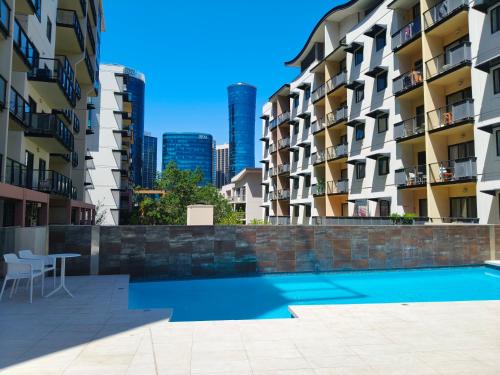 a swimming pool in the middle of two apartment buildings at Resort-style living in Perth CBD - 2X2 Apt in Perth