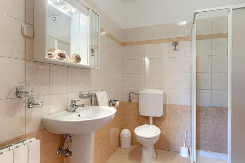 a bathroom with a toilet and a sink and a shower at Faszinierendes Ferienhaus mit Privatpool, Volleyballfeld, Fussballplatz, Trampolin beim bekannten Radweg Parenzana in Vižinada