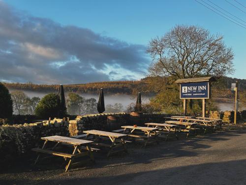 a row of picnic tables in front of a sign at New Inn Appletreewick in Appletreewick