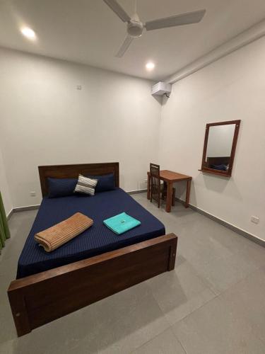 a bedroom with a bed with blue sheets and a mirror at The Nest Kandana in Kandana