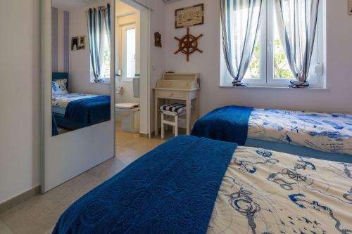 ein Schlafzimmer mit zwei Betten und einem Schreibtisch und einem Spiegel in der Unterkunft Strandnahe Villa mit Meerblick, 2 Bikes, beheiztem Privatpool - nur 300 Meter zum Strand in Dramalj