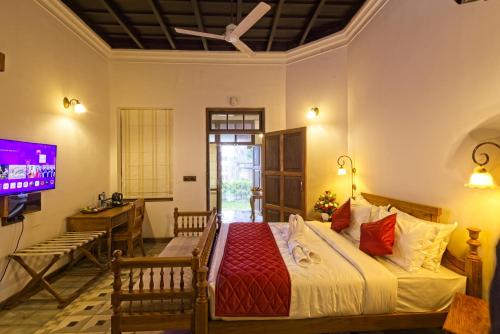 a bedroom with a bed and a tv in a room at Amritha Heritage in Trivandrum