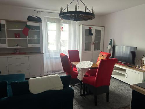 ビャワ・ボドラスカにあるAPARTAMENT przy Parku Radziwiłłaのリビングルーム(テーブル、赤い椅子付)